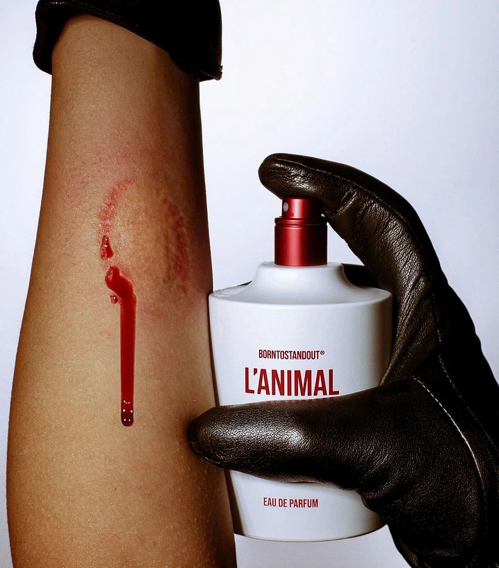Perfume & Fragrance creative ad: Gloved hand pressing a perfume bottle against a bitten forearm
