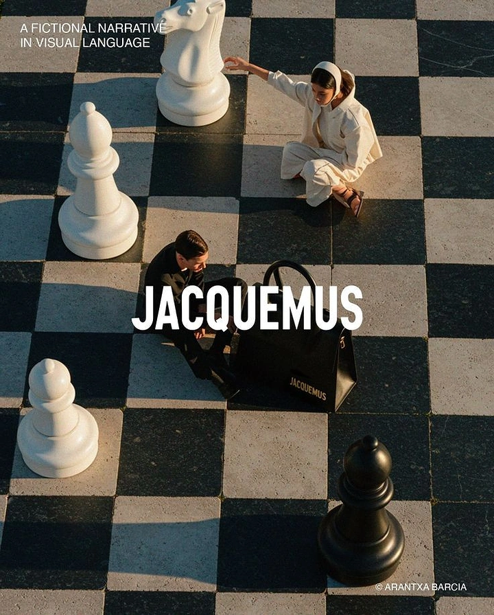 Creative ad: Two models on a giant outdoor chessboard with oversized pieces and a black handbag