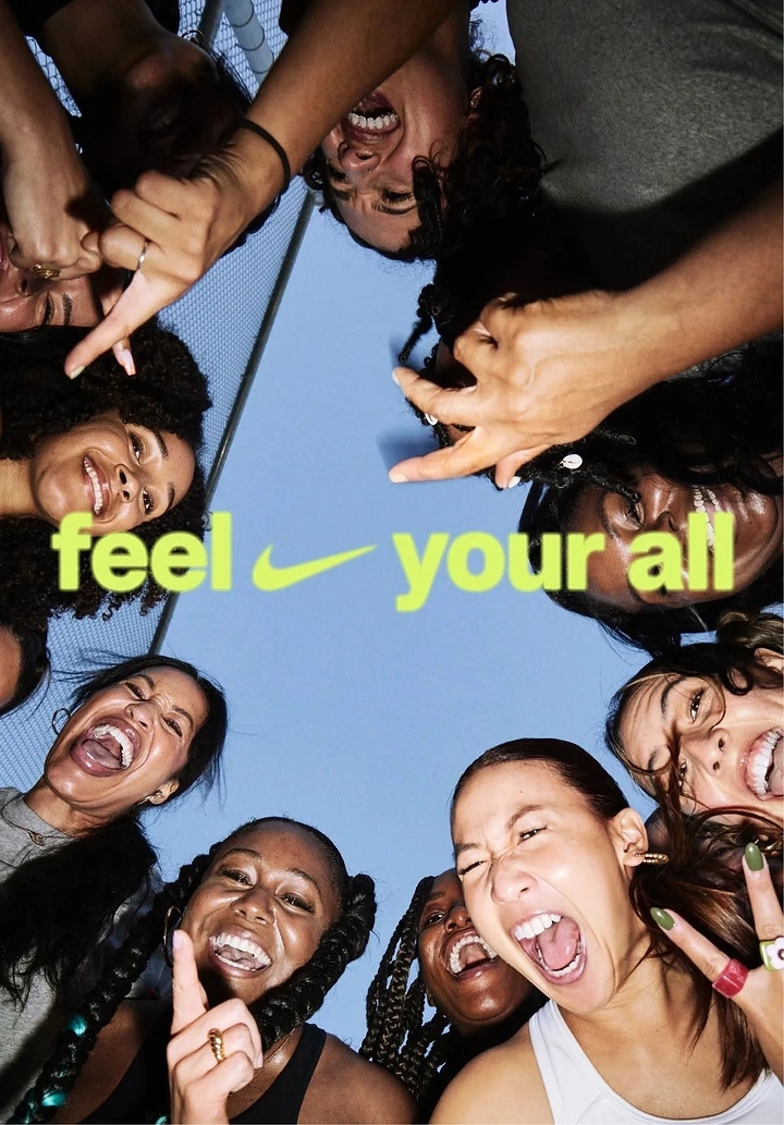 Fashion creative ad: Circle of laughing, shouting women looking down at the camera against the sky