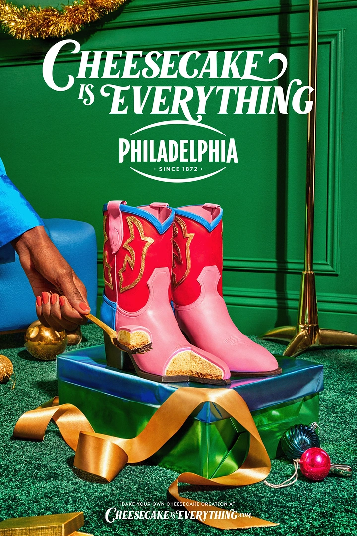 Christmas creative ad: Pink and red cowboy boots made of cheesecake on a wrapped gift, with a hand cutting a slice