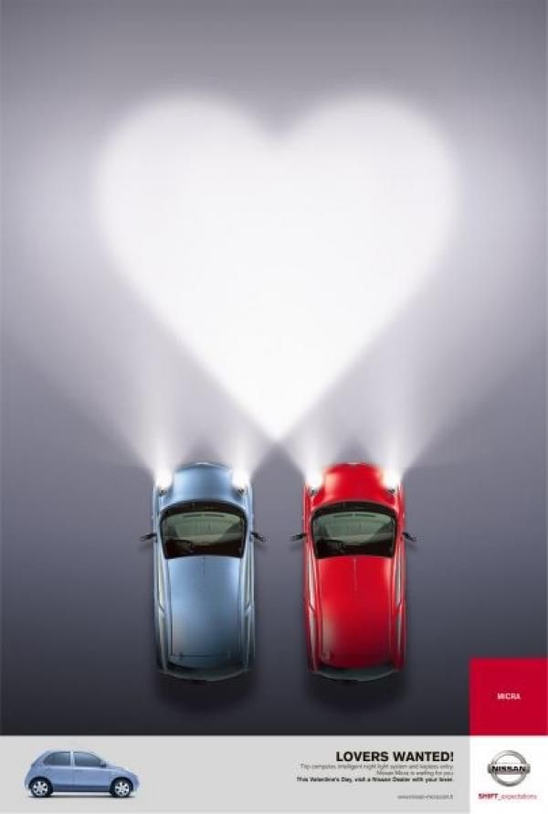 Two cars seen from above whose headlight beams merge into a heart