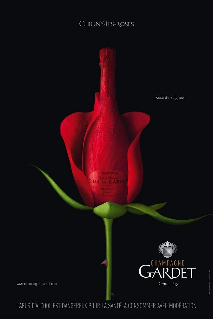 Creative ad: Champagne bottle wrapped in red rose petals on a stem