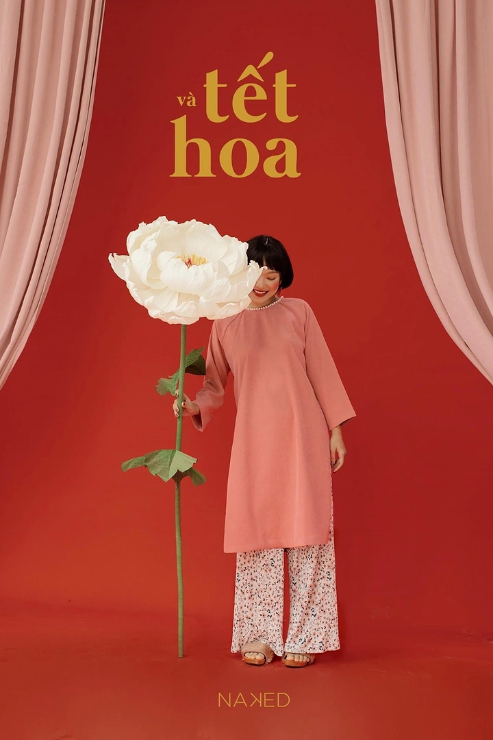Lunar New Year creative ad: Woman in a pink ao dai holding a giant white paper peony