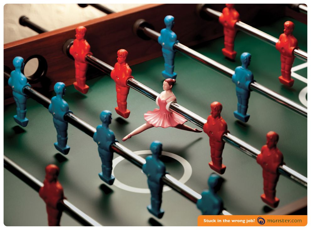 Poster: Pink ballerina figurine skewered on a foosball rod among red and blue players