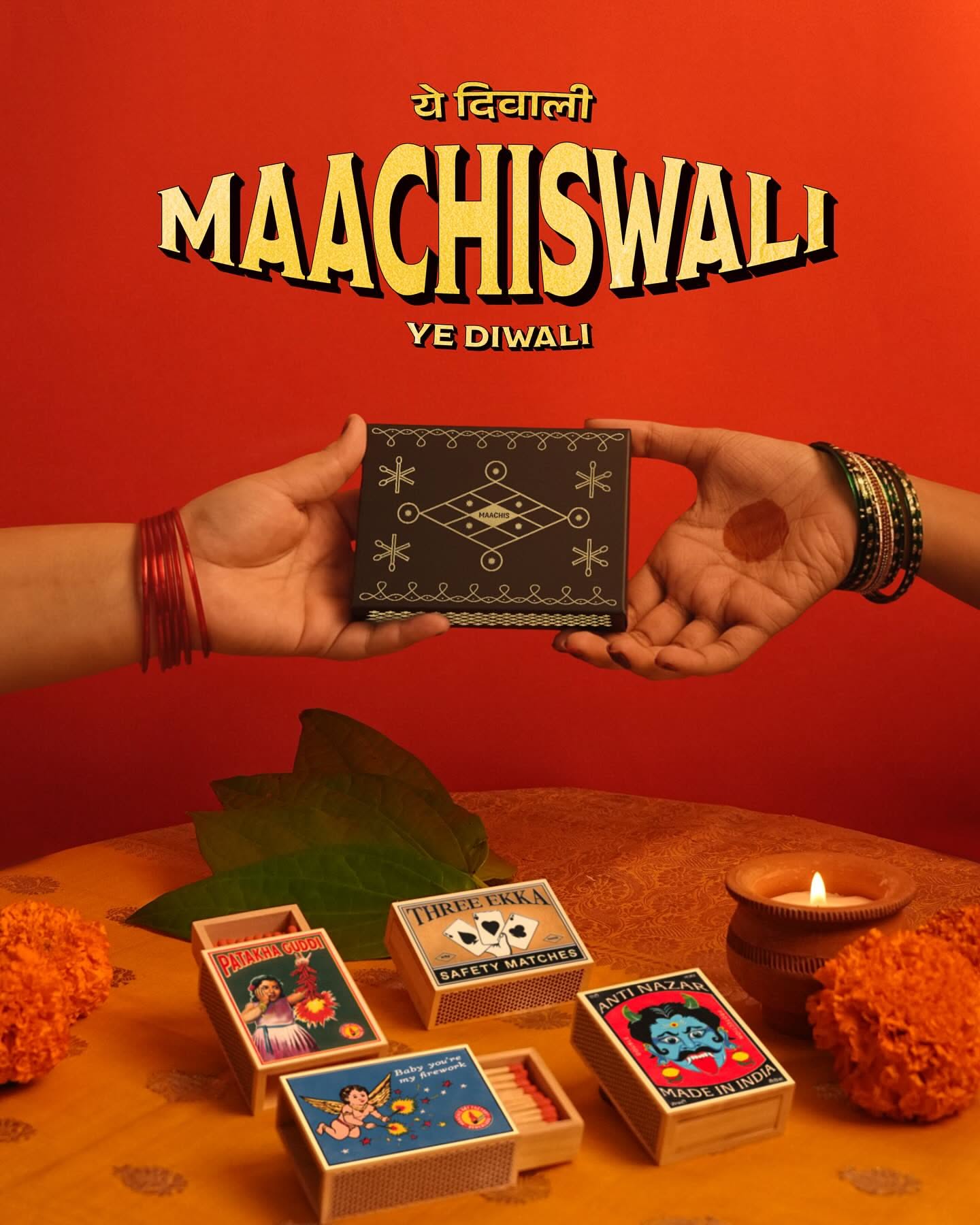 Two hands passing a patterned black matchbox above a table of retro matchboxes