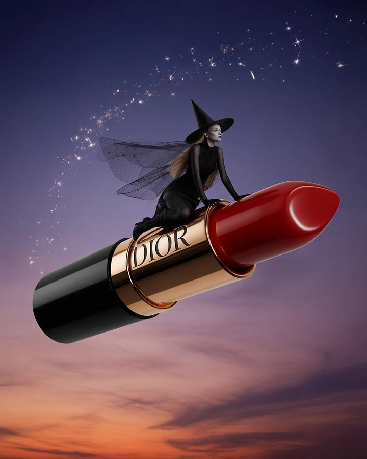 Halloween creative ad: Witch riding a giant red lipstick like a broomstick through the sky