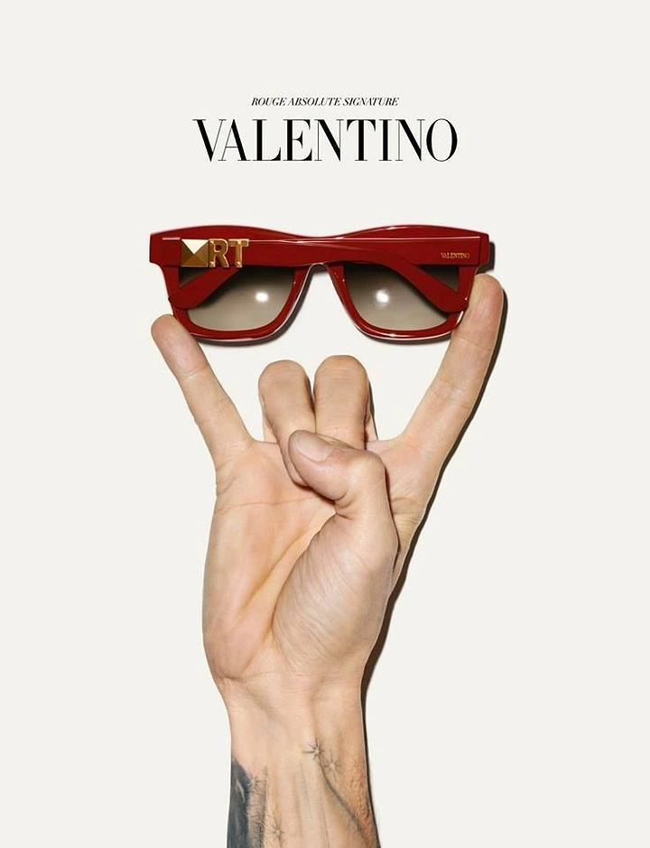 Creative ad: Tattooed hand balancing red sunglasses on its fingertips