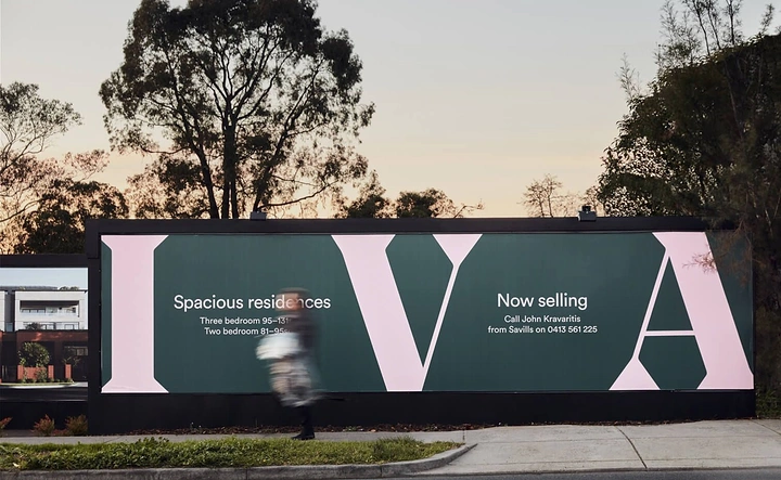 Creative ad: Dark green hoarding with giant pale-pink cropped serif letters