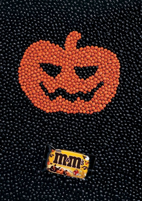 Halloween creative ad: Jack-o'-lantern made of orange candies on black candies