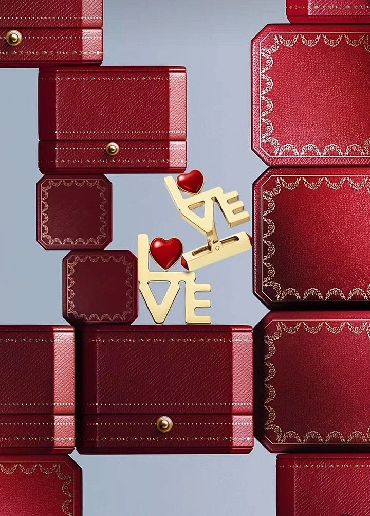 Valentine's Day creative ad: Gold LOVE jewelry on stacked red boxes