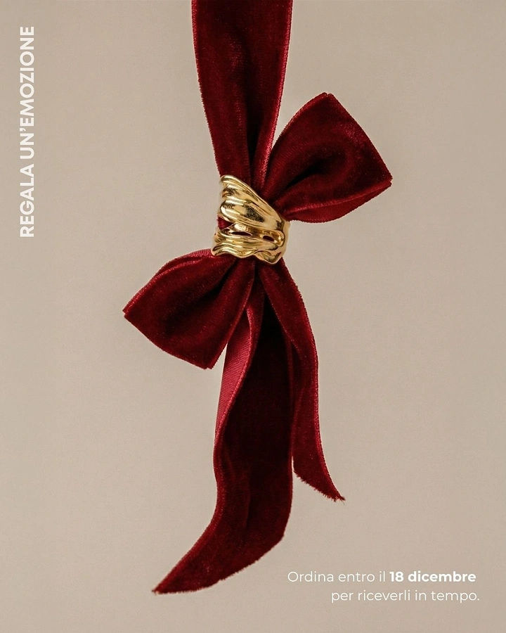 Christmas creative ad: Gold sculptural ring on a red velvet bow