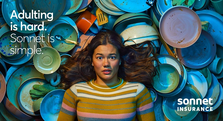Creative ad: Wide-eyed woman lying amid a sea of dirty dishes