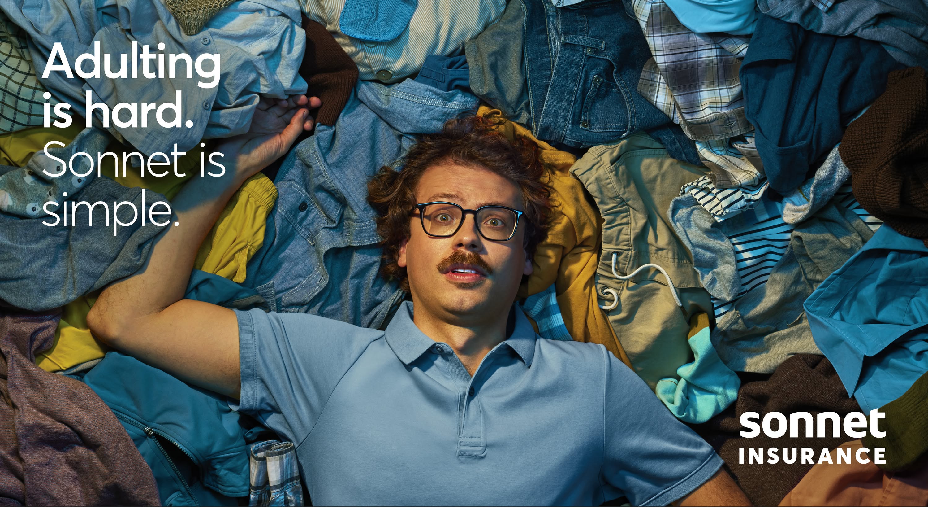 Banner: Startled man lying in a heap of unfolded laundry