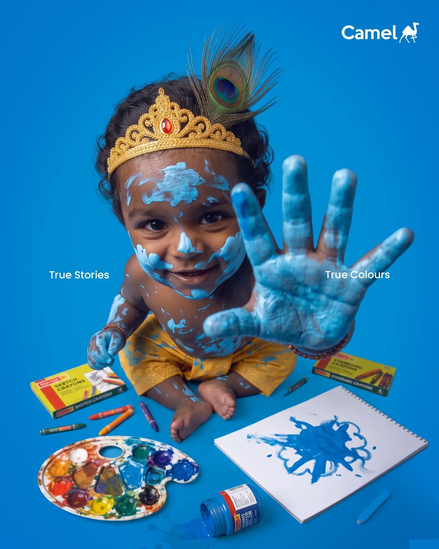 Toddler dressed as Krishna on brick steps reaching for pot