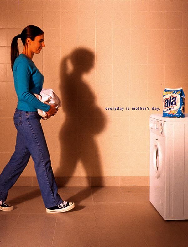 Woman carrying laundry whose shadow shows her pregnant