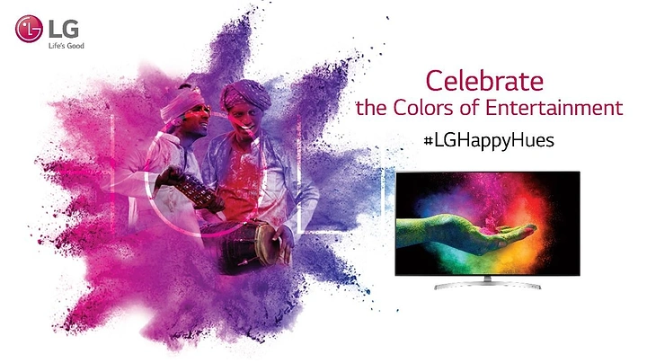 Holi creative ad: Folk musicians in a magenta-purple powder burst beside a TV