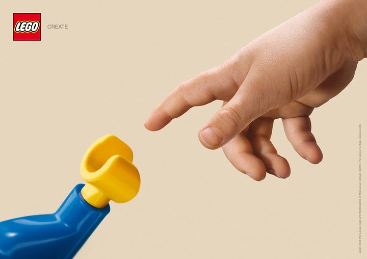 Toy Stores creative ad: Child's hand reaching toward a giant toy minifigure hand, Creation of Adam pose