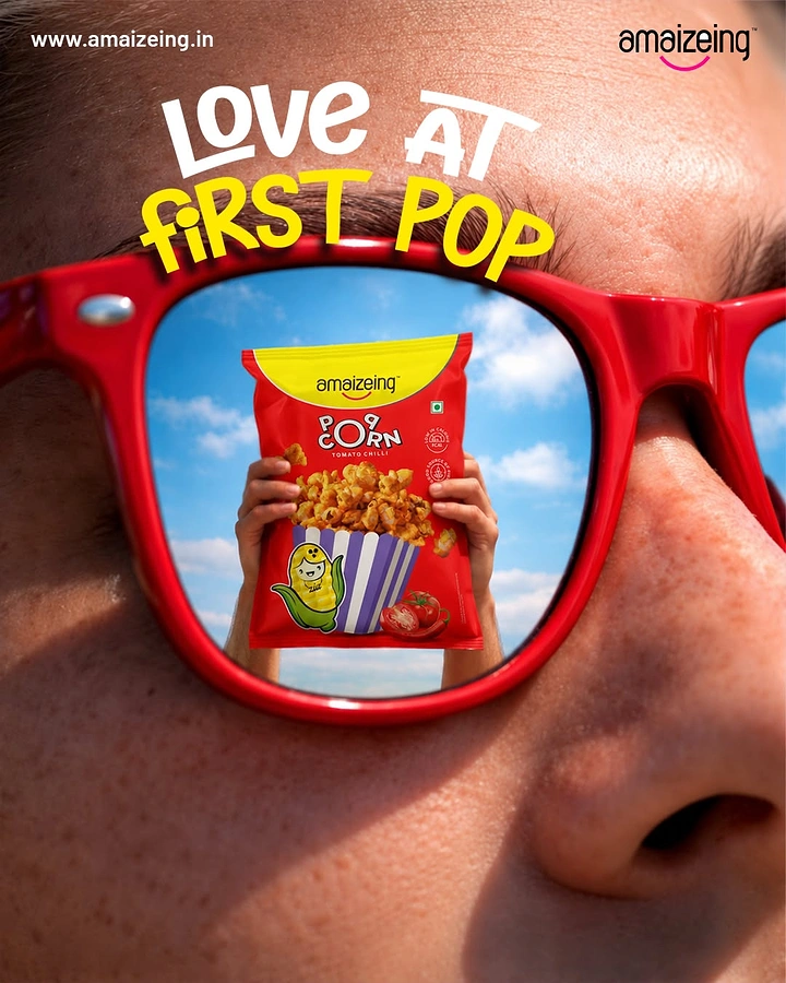 Food & Beverage creative ad: Extreme close-up face in red sunglasses reflecting a popcorn pack held against sky