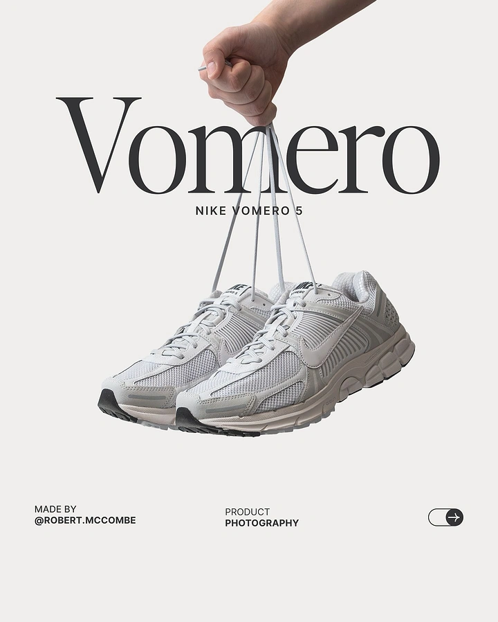 Photography creative ad: A hand dangling a pair of grey running sneakers by their laces