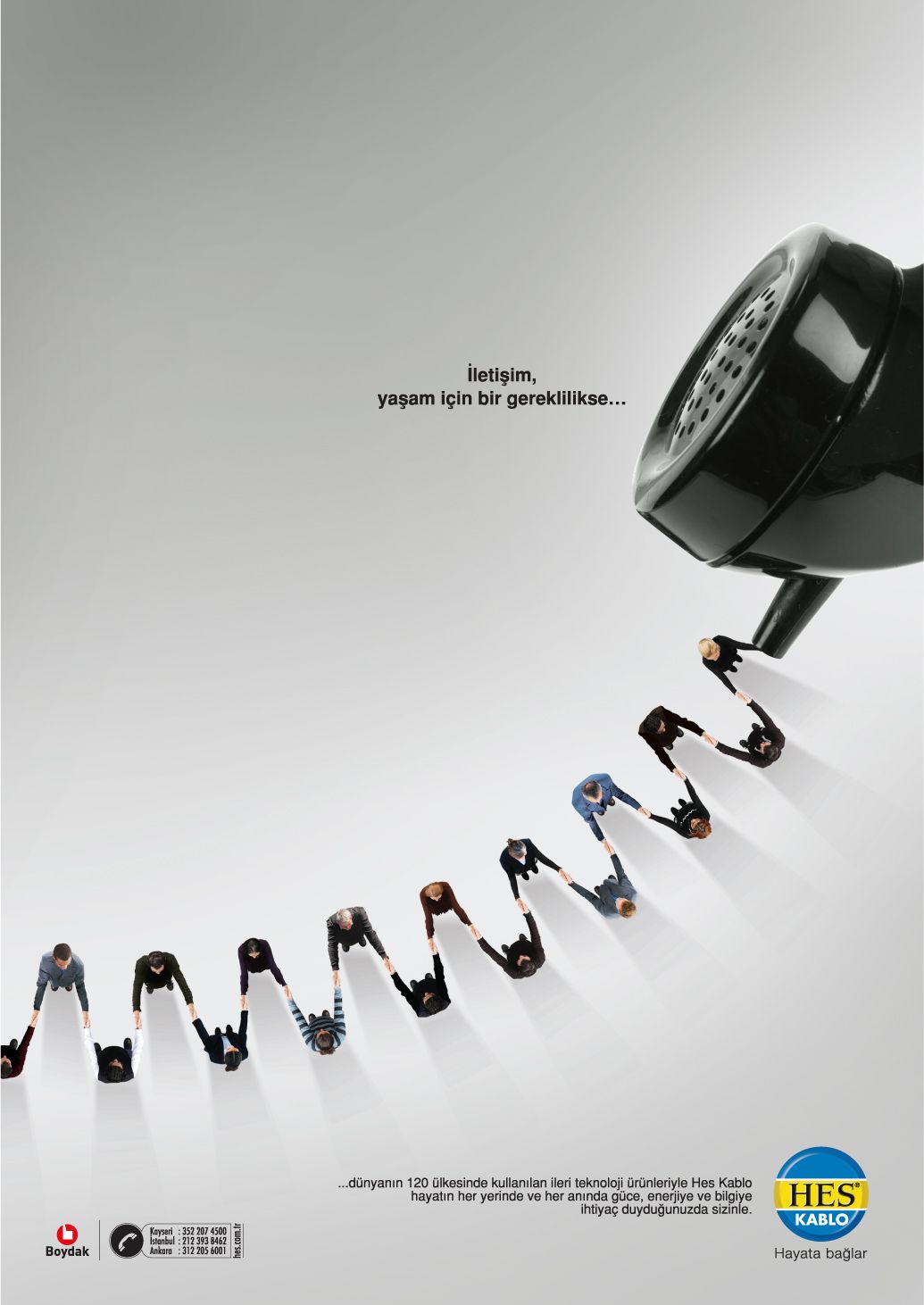 Line of people holding hands, forming a coiled phone cord that runs to a black handset