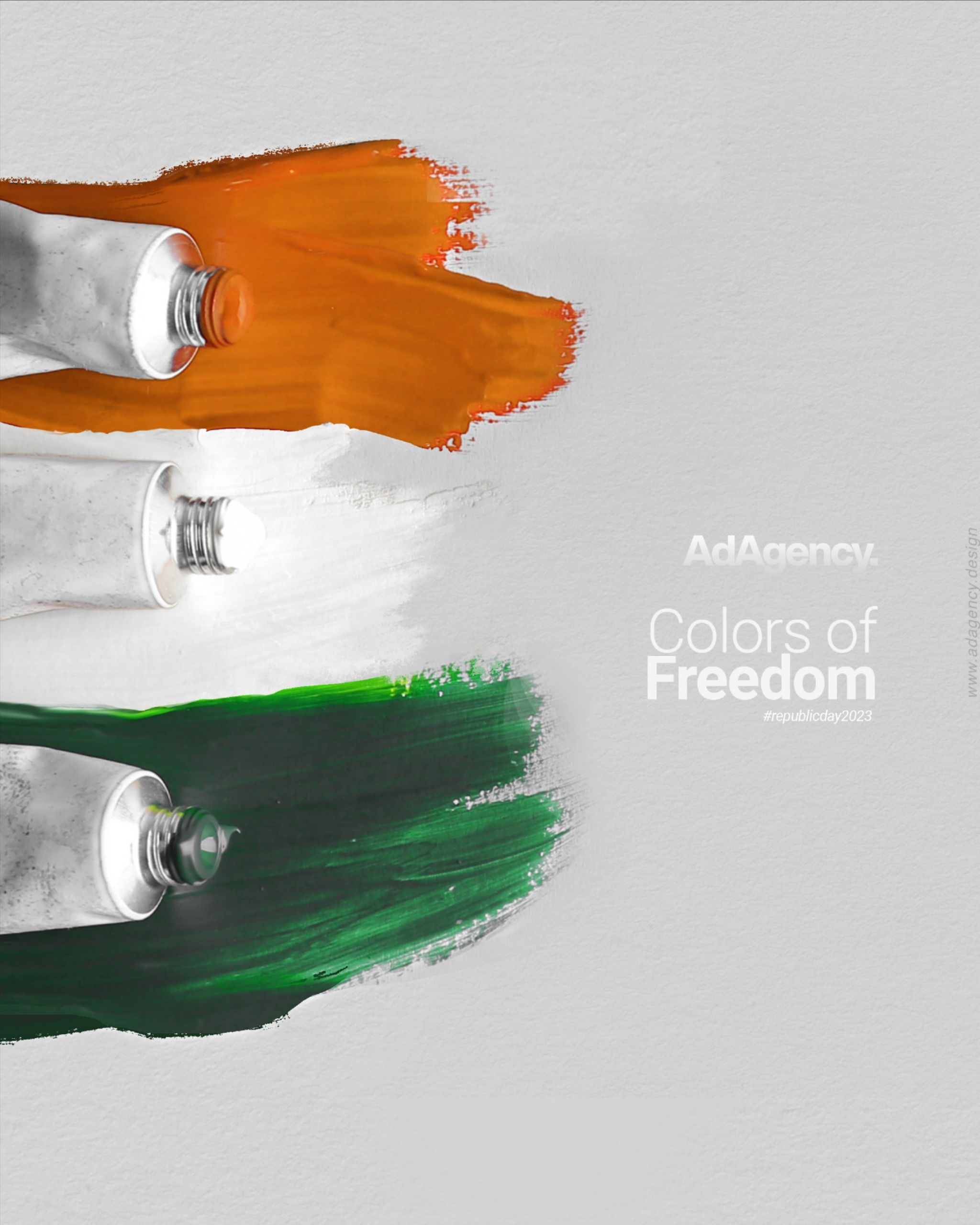 Three paint tubes squeezing out tricolour brush strokes