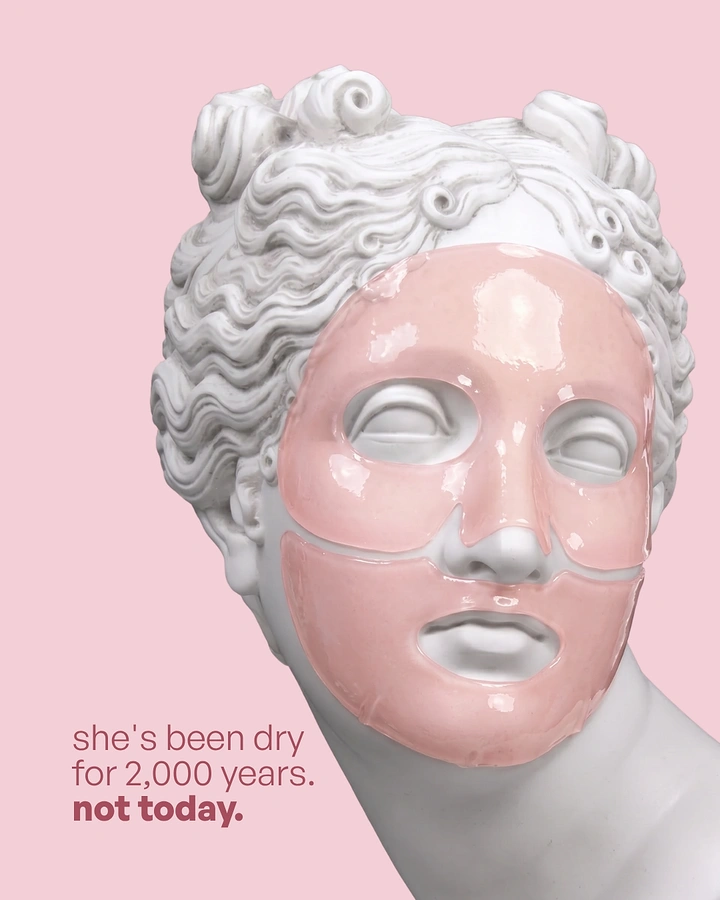 Skincare & Cosmetics creative ad: Classical marble statue head wearing a pink hydrogel face mask