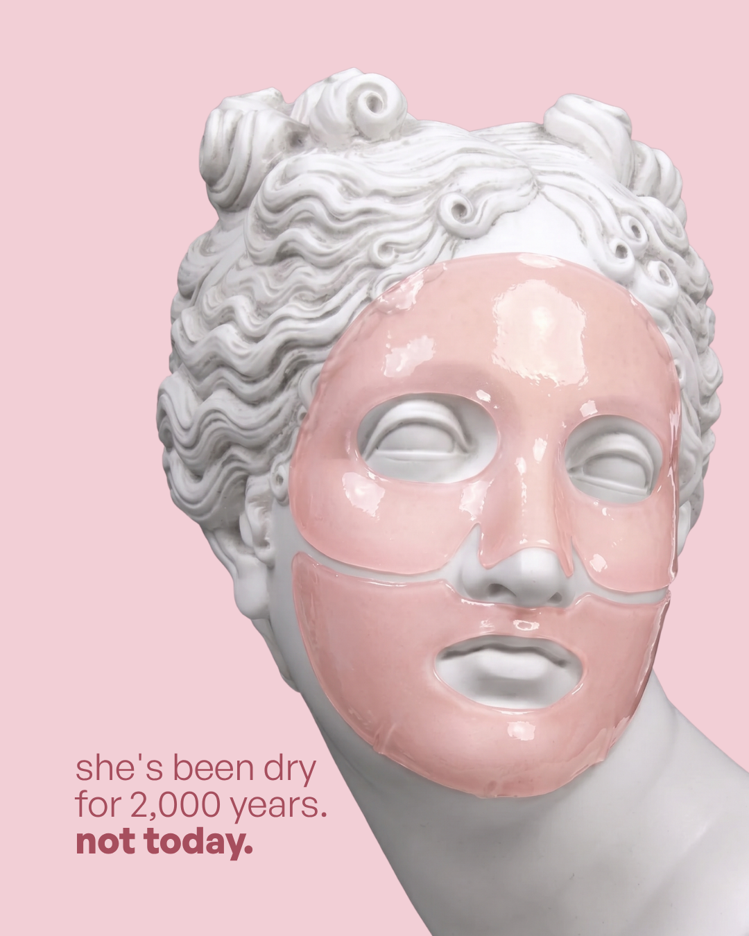 Classical marble statue head wearing a pink hydrogel face mask