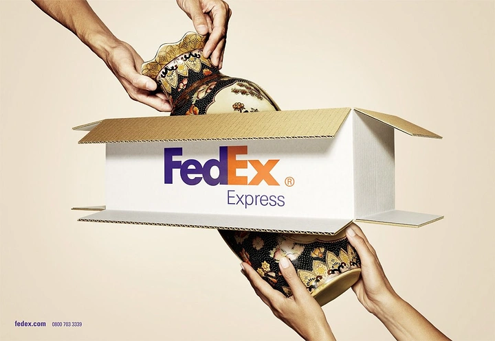 Logistics creative ad: Vase passing through an open-ended shipping box