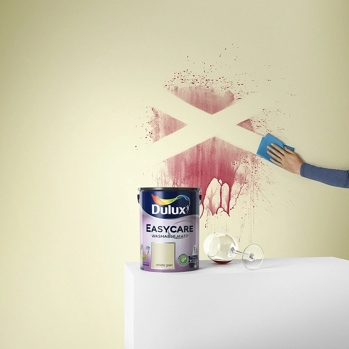 Construction creative ad: Paint tin beside wine-splattered wall being wiped clean