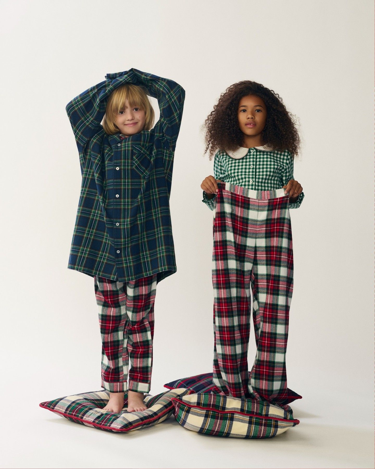 Two models in plaid pyjamas with a giant handwritten letter to Santa