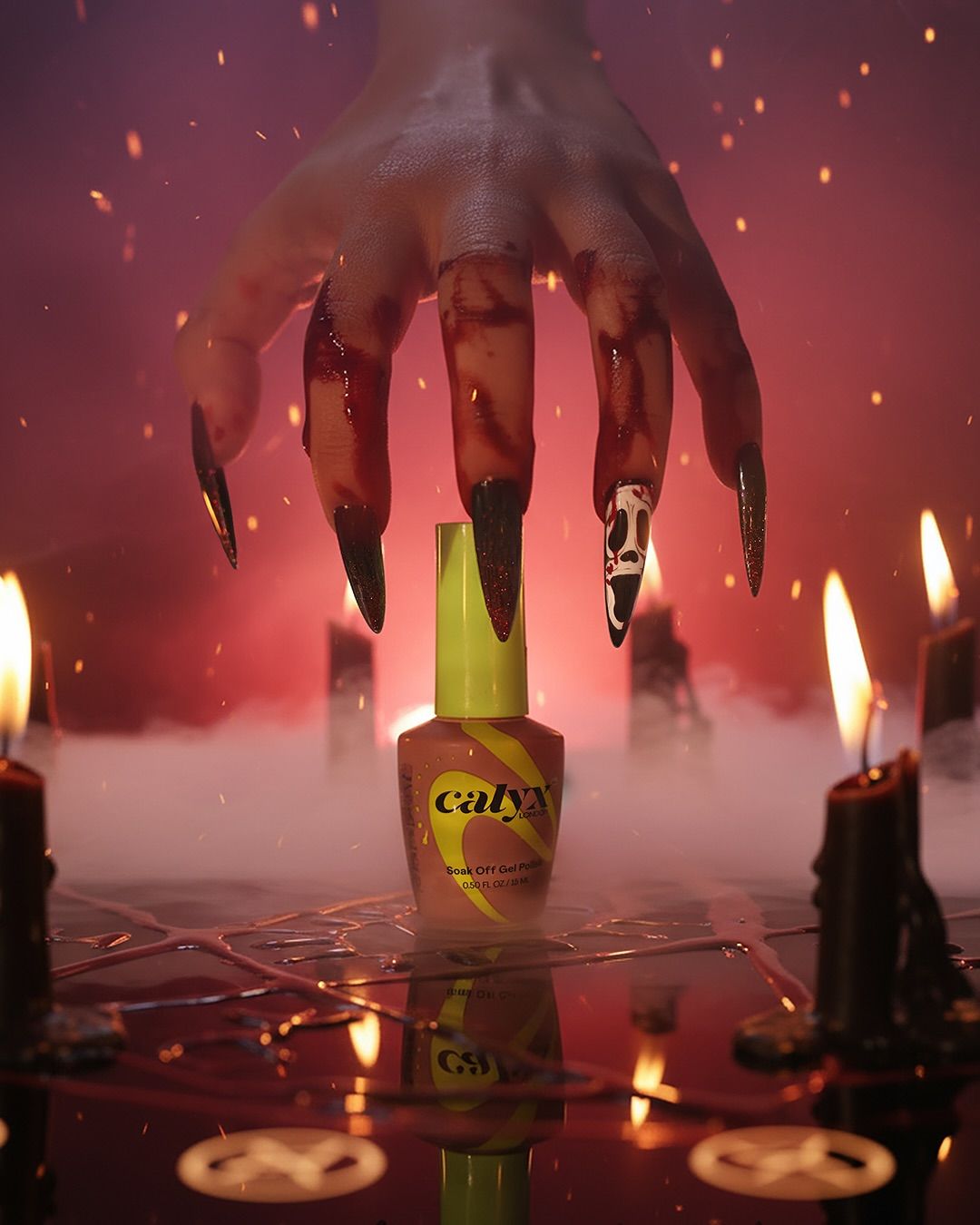 Blood-stained hand with stiletto nails over a gel polish bottle
