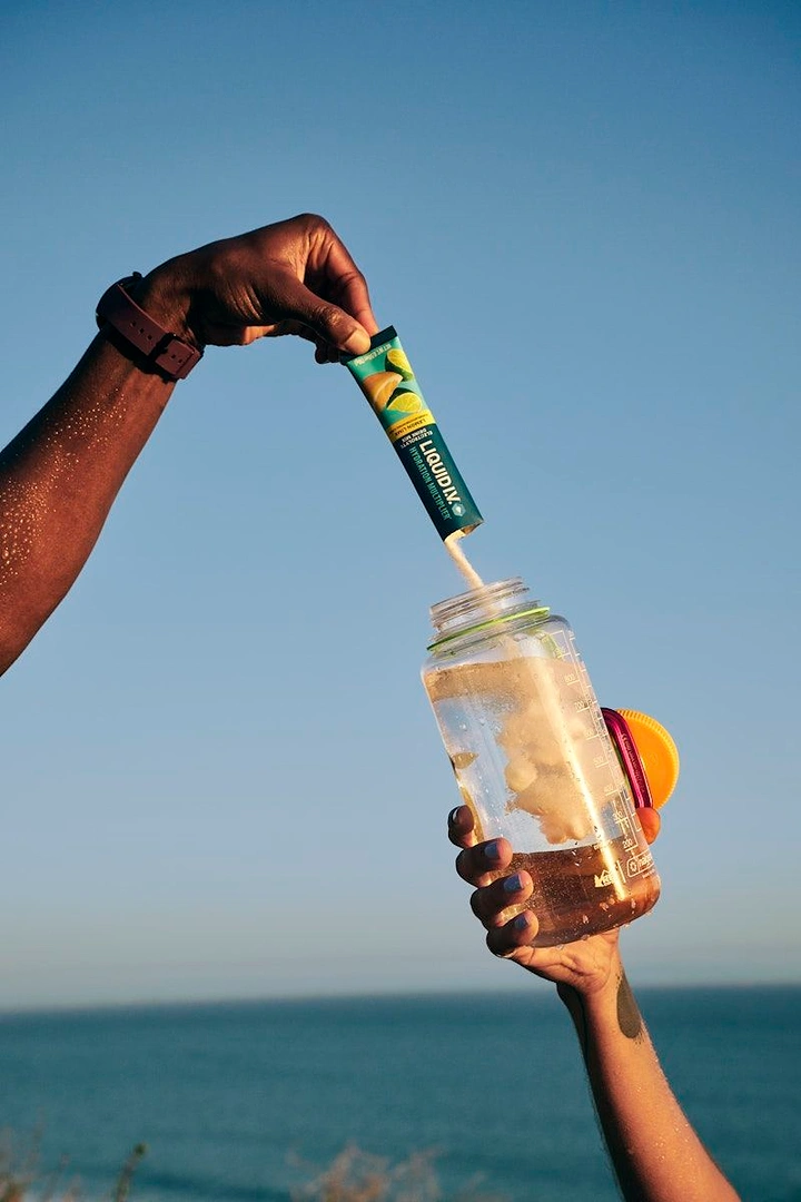 Packaged Drinking Water creative ad: Bottle pours into drink against ocean backdrop