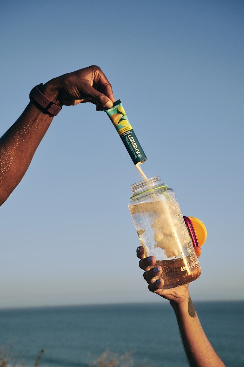 Story: Bottle pours into drink against ocean backdrop