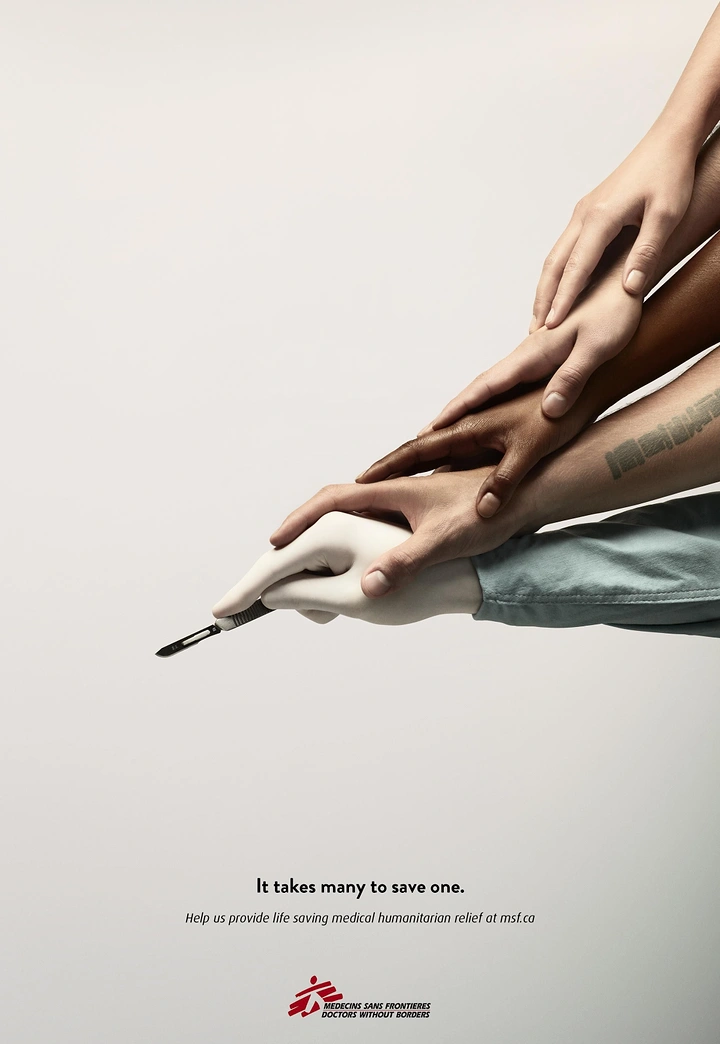 Healthcare creative ad: Many diverse hands stacked on a gloved surgeon's hand holding a scalpel